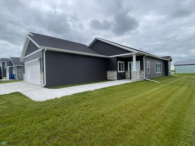 view of front facade with stone siding, a front yard, a garage, and concrete driveway