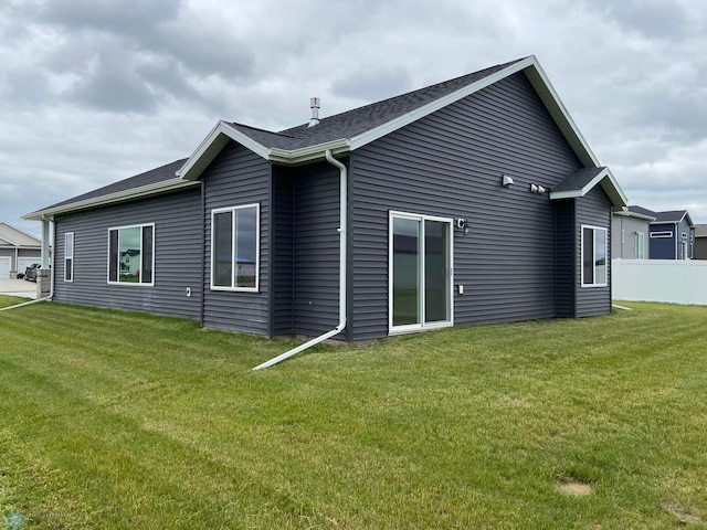rear view of house featuring roof with shingles