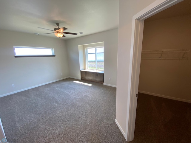 unfurnished bedroom with multiple windows, carpet flooring, baseboards, and ceiling fan