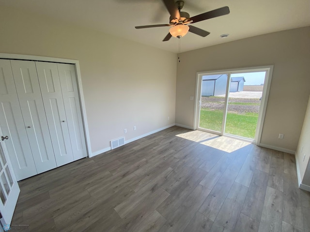 unfurnished bedroom with a ceiling fan, a closet, baseboards, visible vents, and wood finished floors
