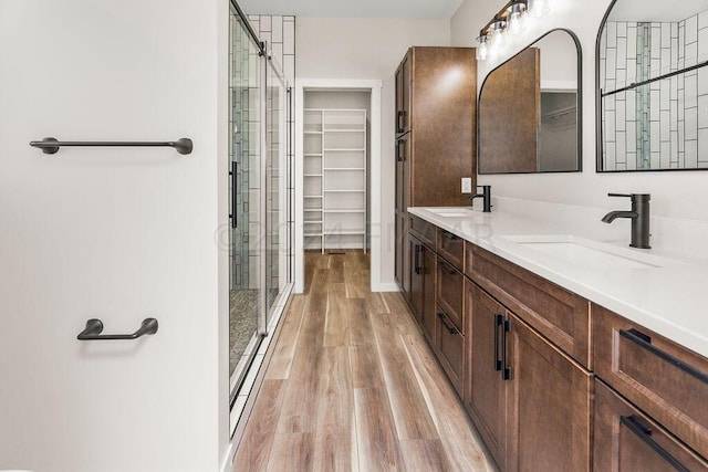 bathroom featuring double sink vanity, hardwood / wood-style floors, and an enclosed shower