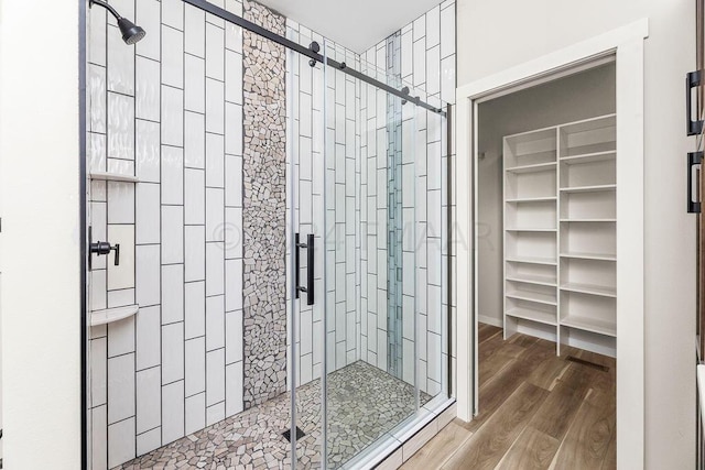 bathroom with a shower with door and hardwood / wood-style flooring