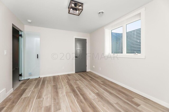 unfurnished bedroom with light wood-type flooring