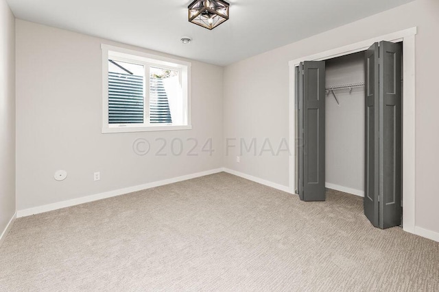 unfurnished bedroom with light carpet and a closet