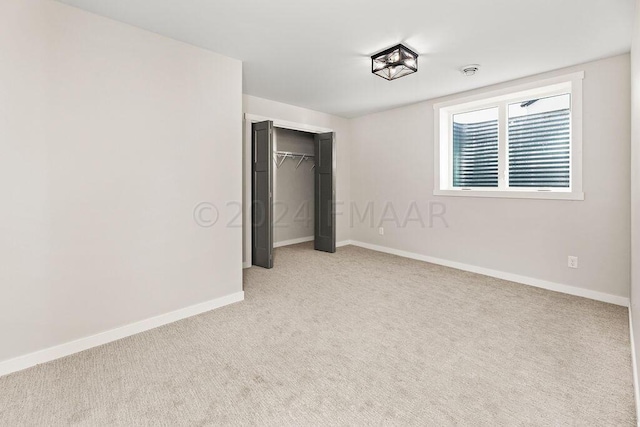 unfurnished bedroom with a closet and light colored carpet