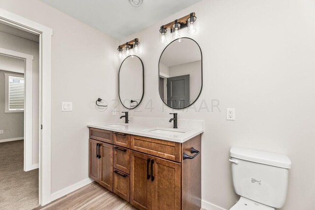 bathroom featuring dual vanity and toilet