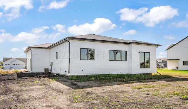 back of property featuring a garage and central AC