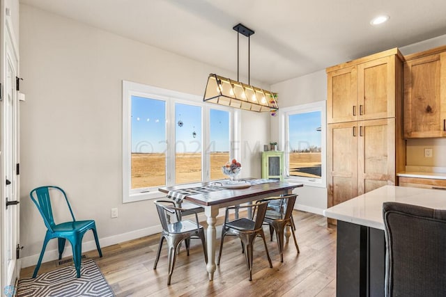 dining room with recessed lighting, light wood-style flooring, and baseboards