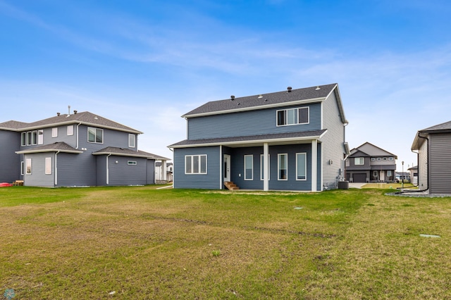 back of property with a lawn and roof with shingles