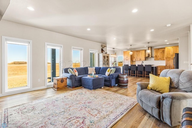 living room featuring light wood finished floors, recessed lighting, and baseboards