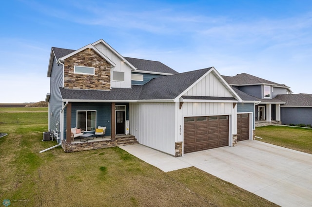 view of front of home featuring board and batten siding, a front yard, roof with shingles, stone siding, and an attached garage
