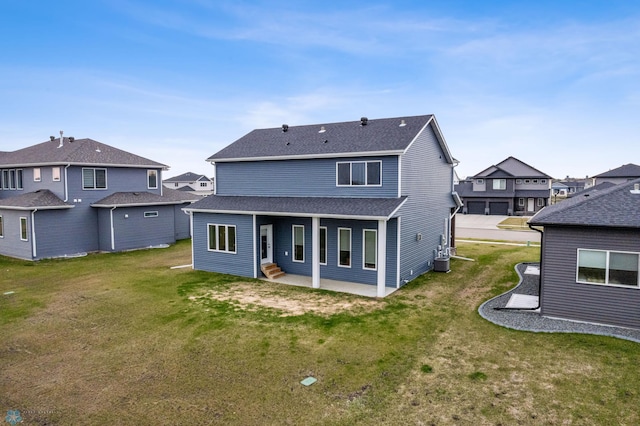 back of house featuring a shingled roof, a residential view, central AC, a yard, and a patio