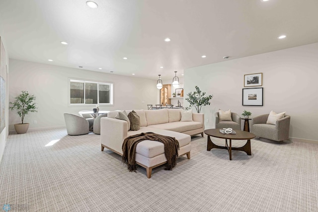 living room featuring light colored carpet, baseboards, and recessed lighting