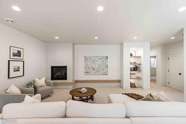 living room with light colored carpet, baseboards, a large fireplace, and recessed lighting