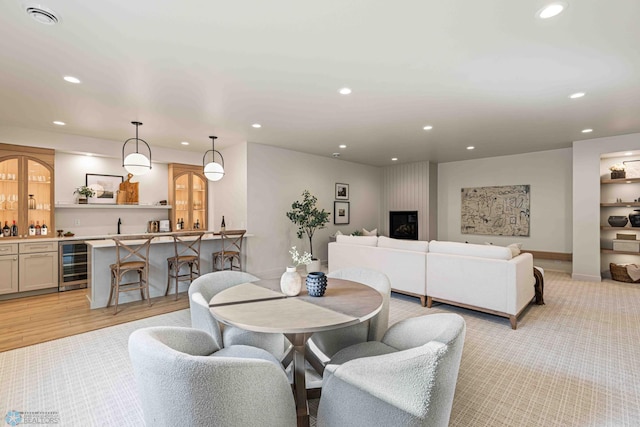 dining space featuring indoor wet bar, beverage cooler, and recessed lighting