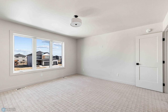 spare room featuring visible vents, baseboards, and carpet