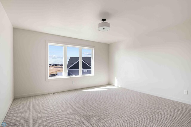 empty room with carpet and baseboards