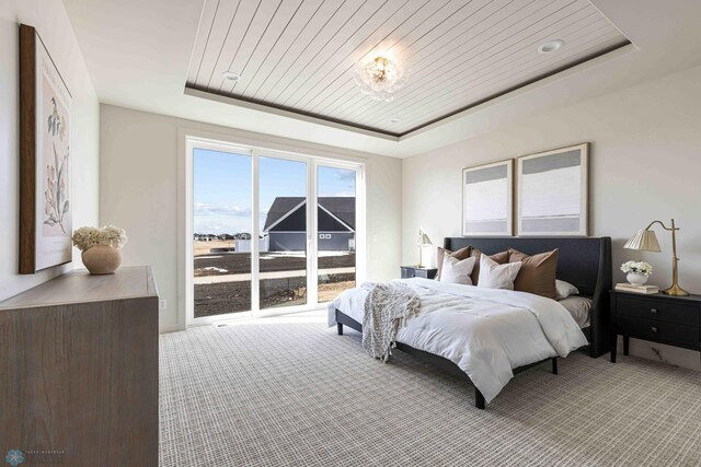 bedroom featuring carpet, a tray ceiling, and wooden ceiling