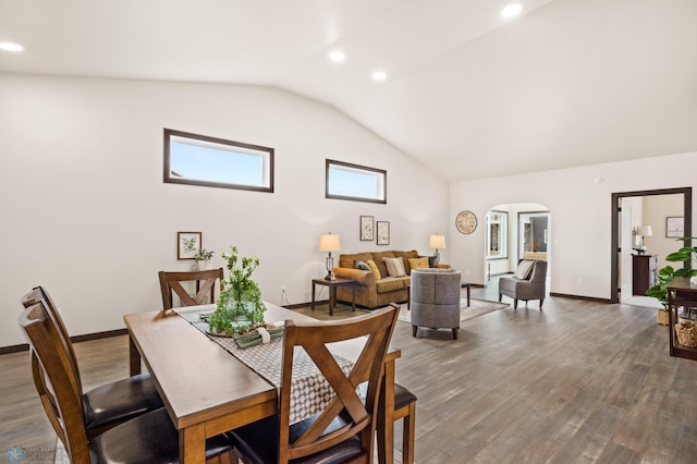 dining area featuring hardwood / wood-style floors and vaulted ceiling