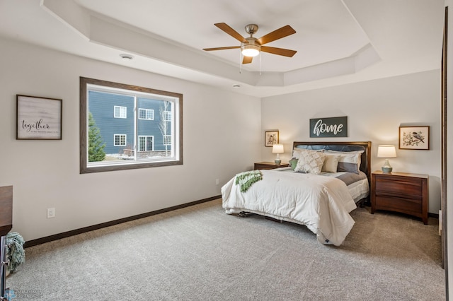 bedroom featuring carpet, ceiling fan, and a tray ceiling