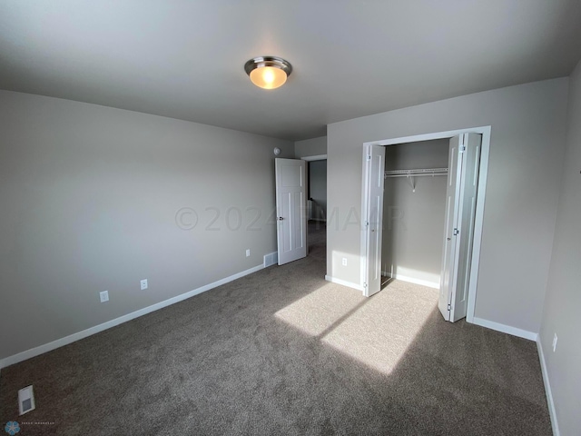 unfurnished bedroom featuring a closet and dark carpet