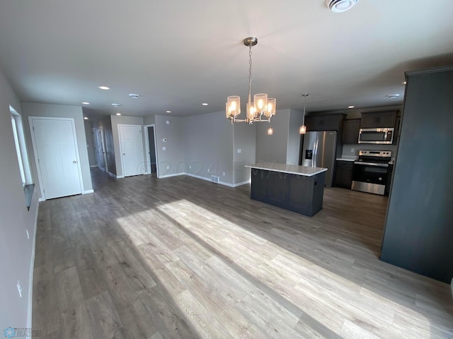 1316 Southview Dr SW, Glyndon, MN 56547 - kitchen with stainless steel appliances, open floor plan, a center island, light countertops, and a chandelier