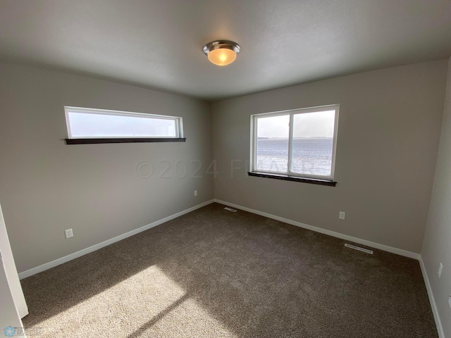 1316 Southview Dr SW, Glyndon, MN 56547 - spare room featuring dark colored carpet and baseboards
