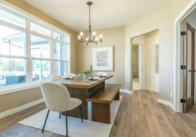 dining room with a notable chandelier and light wood-type flooring