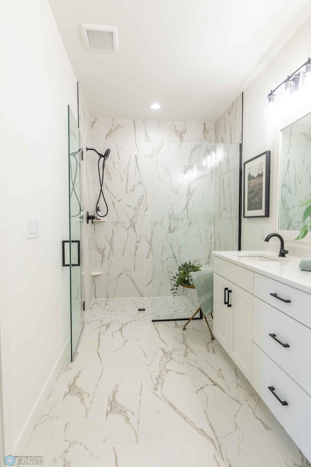 bathroom featuring a tile shower and vanity