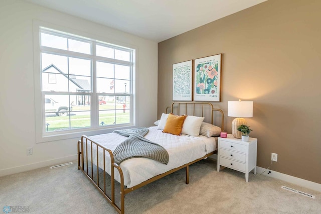 bedroom featuring light carpet and multiple windows