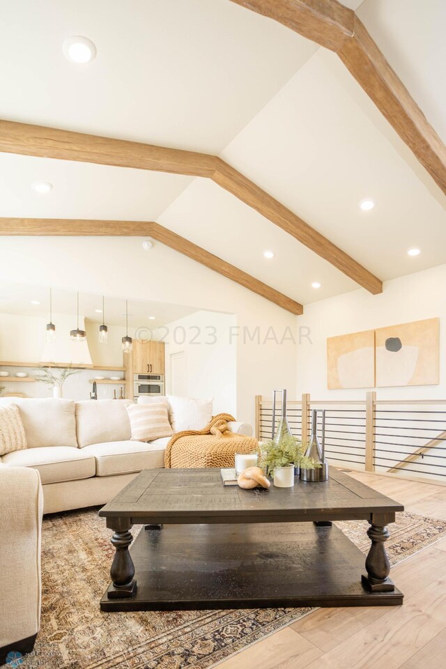 living room featuring lofted ceiling with beams and hardwood / wood-style flooring