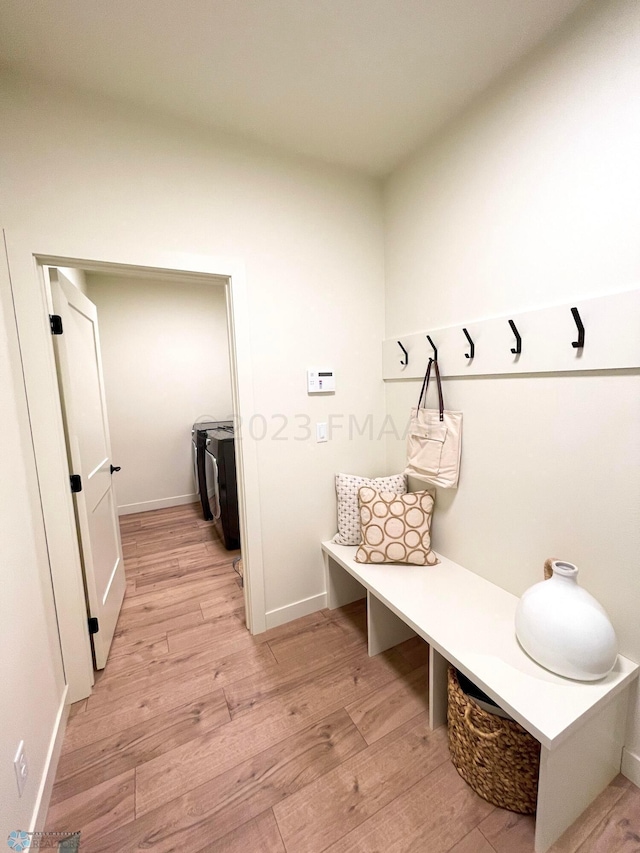 mudroom featuring washer and clothes dryer and light hardwood / wood-style floors