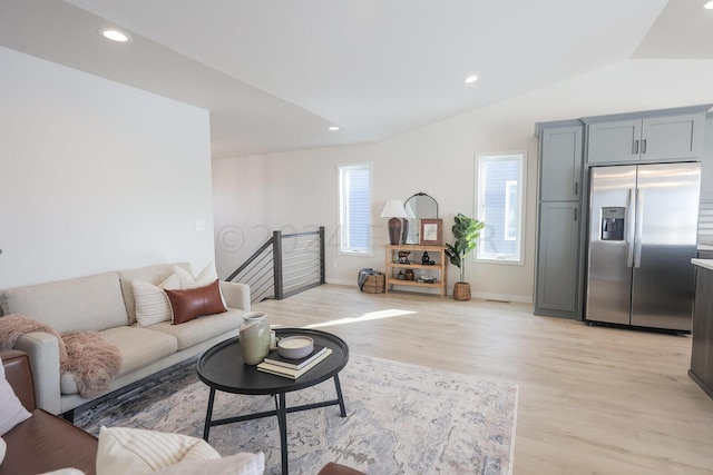 living room with lofted ceiling and light hardwood / wood-style flooring