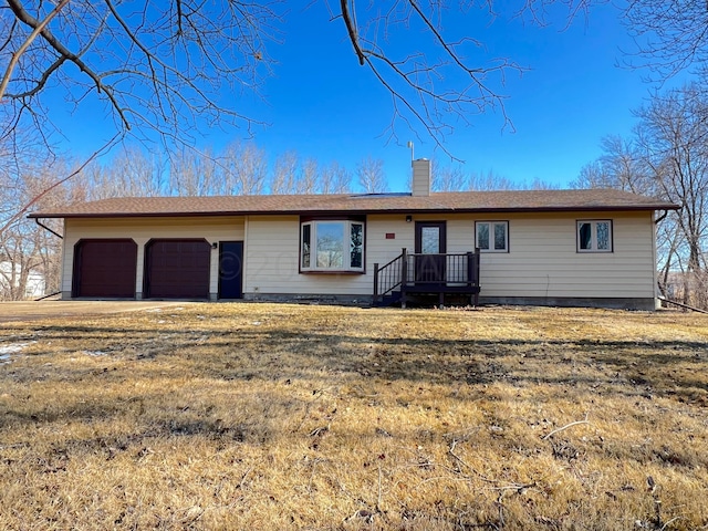 single story home with a garage, a chimney, and a front lawn