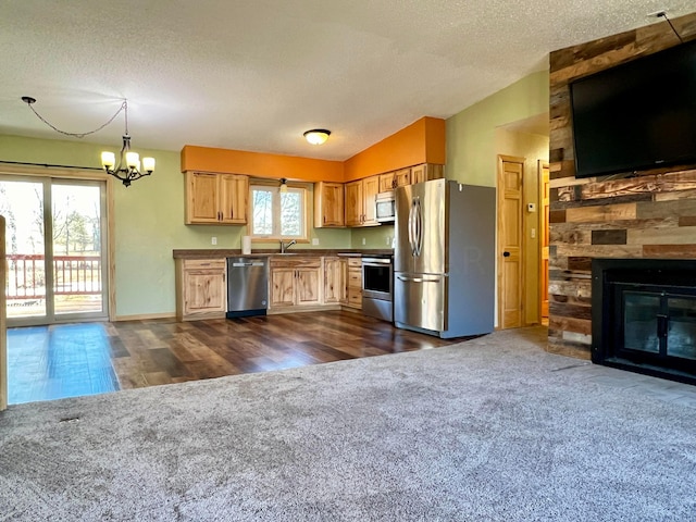 kitchen featuring open floor plan, dark colored carpet, appliances with stainless steel finishes, and lofted ceiling