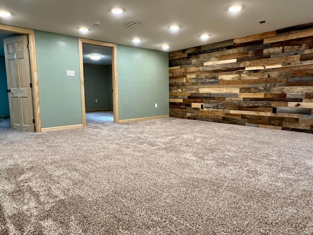 spare room featuring wood walls, carpet, baseboards, and recessed lighting