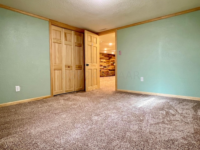 unfurnished bedroom featuring carpet, a textured wall, a textured ceiling, and baseboards