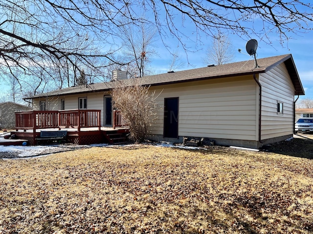 rear view of property with a chimney and a wooden deck