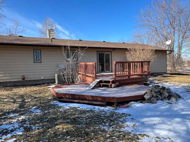 snow covered property featuring a chimney and a deck