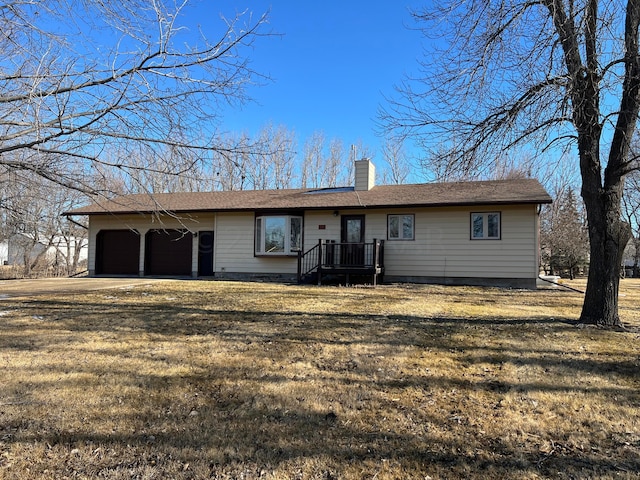 ranch-style home with a garage, driveway, a front lawn, and a chimney