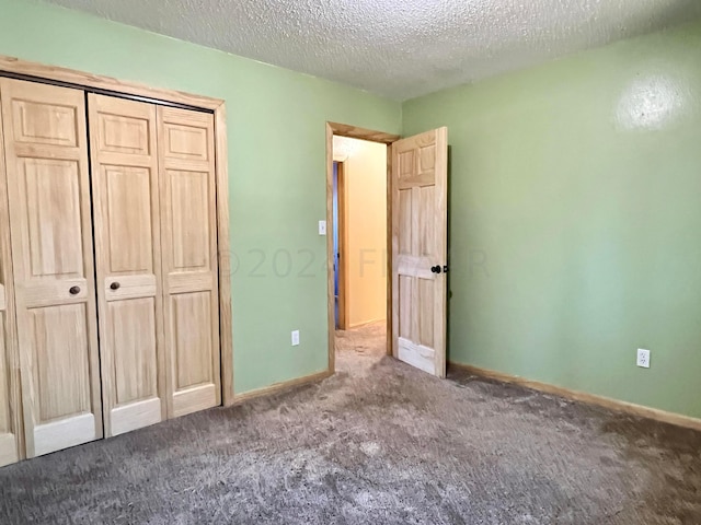 unfurnished bedroom with a textured ceiling, a closet, carpet, and baseboards