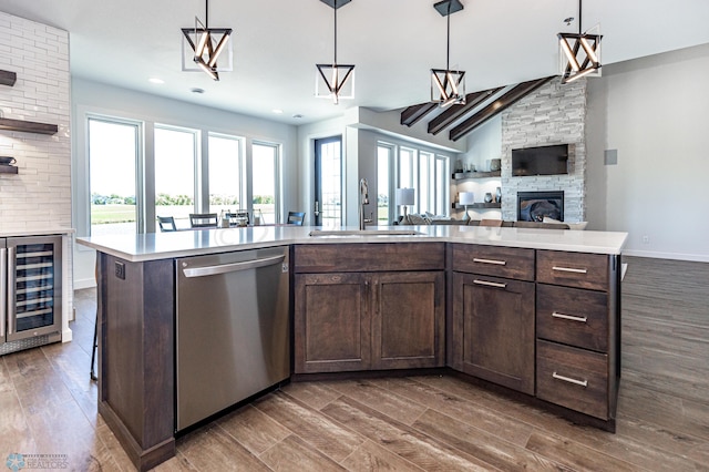 kitchen featuring a kitchen island with sink, stainless steel dishwasher, and wood-type flooring