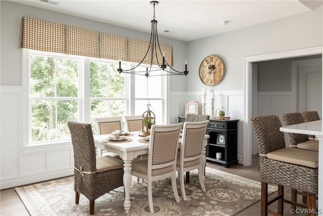 dining space with a chandelier, a healthy amount of sunlight, and light hardwood / wood-style flooring