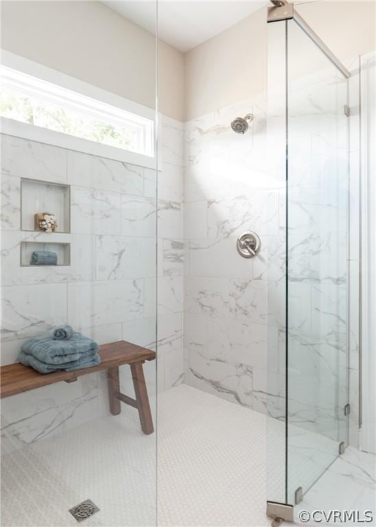 bathroom featuring walk in shower and tile walls