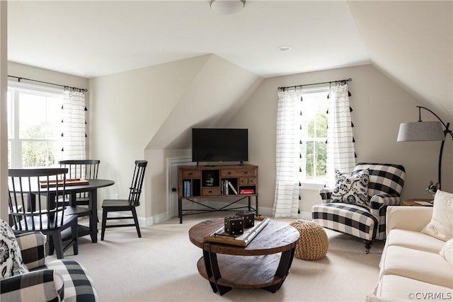 carpeted living room featuring plenty of natural light and vaulted ceiling