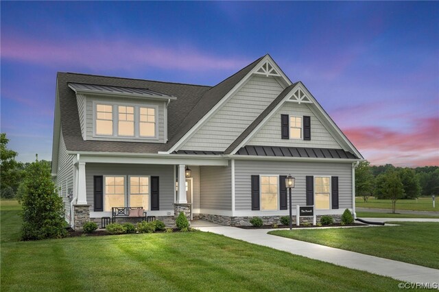 craftsman-style house featuring covered porch and a yard