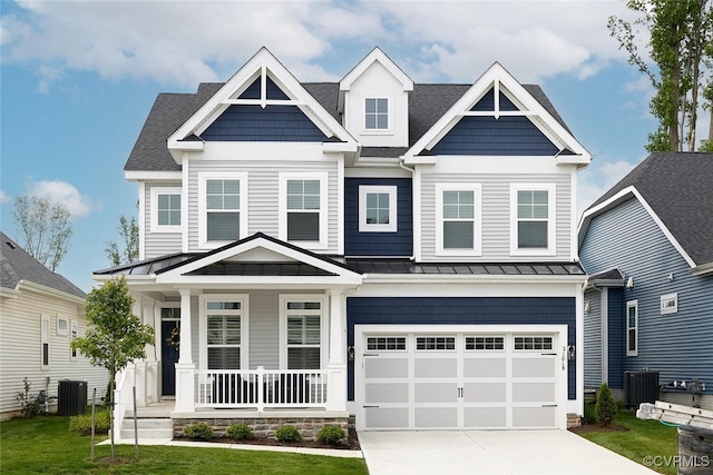 craftsman-style house featuring a garage, central AC, covered porch, and a front yard