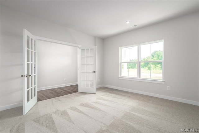 unfurnished bedroom featuring light carpet and french doors