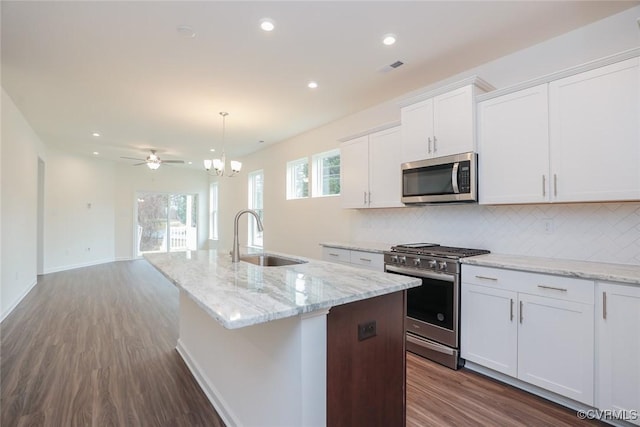 kitchen featuring stainless steel appliances, white cabinetry, sink, and a center island with sink