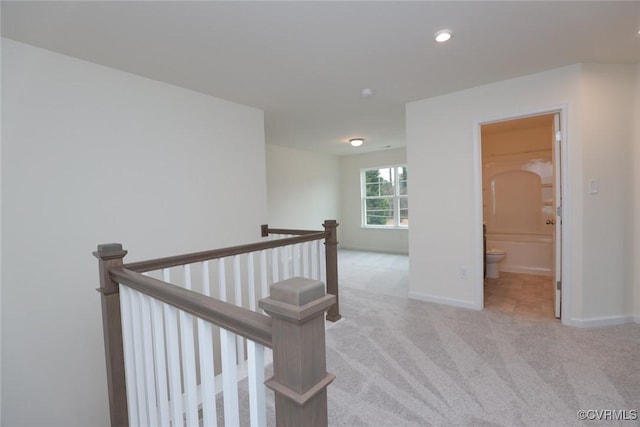 hallway featuring light colored carpet